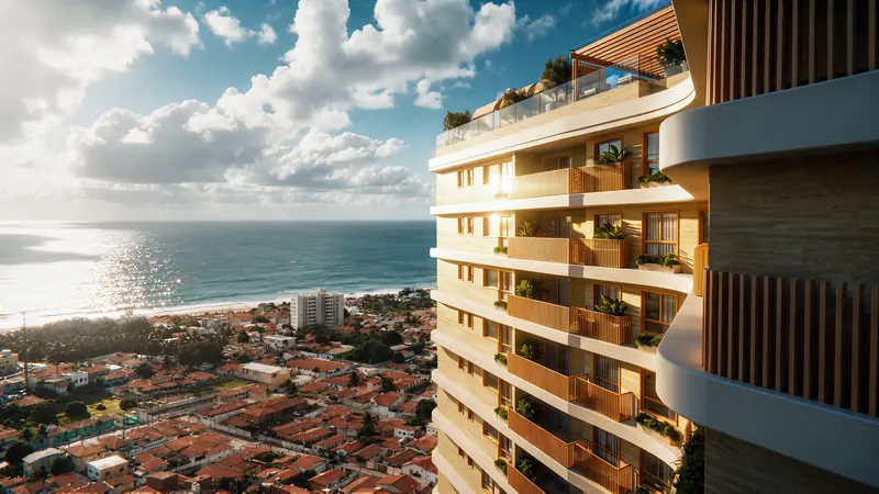 Fachada lateral de torre com varandas curvas e brises de madeira, vista do alto, com bairro de telhados cerâmicos, praia e mar ao fundo sob céu com nuvens.